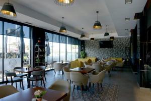 BelshPerla e Dumrese, Bar-Restaurant-Hotel的餐厅设有桌椅和窗户。