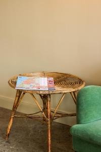 韦斯特兰Mimosa Hotel的绿色椅子旁边的柳条桌和桌子