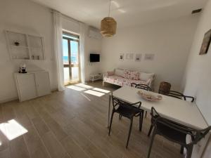 丽都玛里尼Appartamento Demetrio 50m mare & shopping的客厅配有桌椅和沙发