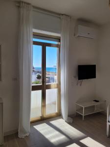 丽都玛里尼Appartamento Demetrio 50m mare & shopping的客房设有滑动玻璃门,享有海景。