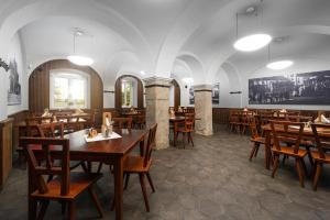 SvijanyHotel Zámek Svijany的用餐室配有木桌和椅子