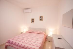 费拉约港Villetta Capo Bianco - Goelba的白色卧室配有床和书桌