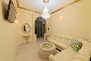 雅典LUXURY AND COMFORTABLE VILLA的客厅配有白色沙发和吊灯。