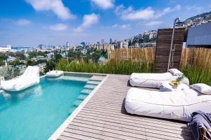 海法SERENE - Infinity Cview pool - 4 bedrooms Luxury Penthouse的木制甲板上配有枕头的游泳池