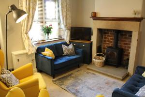 贝克韦尔No2 Woodland View的客厅设有蓝色的沙发和壁炉