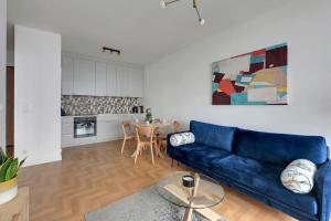 格丁尼亚Apartament w Gdyni - Plac Unii by Grand Apartments的一间带蓝色沙发的客厅和一间厨房