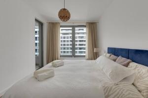 格丁尼亚Apartament w Gdyni - Plac Unii by Grand Apartments的窗户客房内的一张大白色床