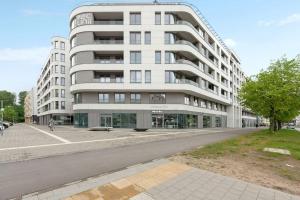 格丁尼亚Apartament w Gdyni - Plac Unii by Grand Apartments的前面有一条街道的白色大建筑
