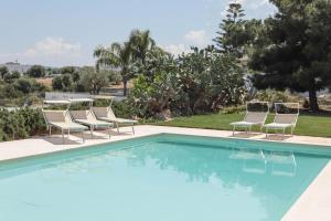 莫诺波利Villa Dyria exclusive swimming pool的一个带躺椅的游泳池和一个游泳池