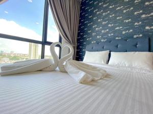 新山SKS Pavilion Residence by UHA的床上有两条天鹅形毛巾