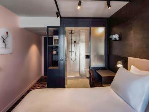 巴黎TRIBE Paris Batignolles的酒店客房配有一张床和淋浴