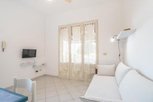兰佩杜萨Villetta Bianca的白色的客厅配有白色的沙发和电视