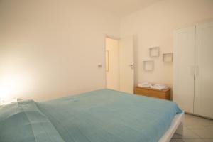 兰佩杜萨Villetta Bianca的白色卧室配有蓝色的床和橱柜