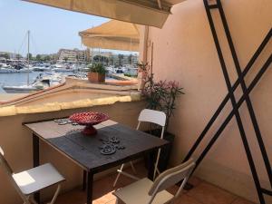阿格德角Résidence Port Soleil B453的阳台享有海港景致,配有桌椅。