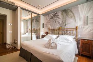 蒙特格罗托泰梅Terme Preistoriche Resort & Spa的卧室配有一张白色大床,上面有弓