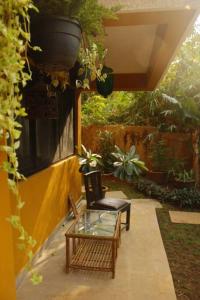 达波林The Burrow in South Goa.的一个带玻璃桌和椅子的庭院