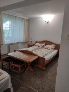 卡赞勒克Хотел ЗЛАТНА КОТВА的一间卧室配有一张床和一张木桌