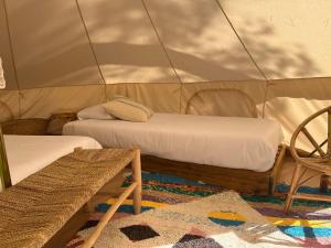 巴利-略夫雷加Camping 3 Estrellas Costa Brava的帐篷内的房间,配有两张床和一把椅子
