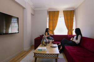 开塞利Seyir Evleri DİVAN的两个女人坐在客厅的沙发上