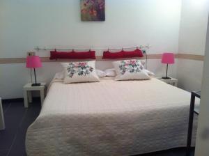 博纳索拉佩西恩摩德纳酒店的一间卧室配有一张大床和两盏粉色灯