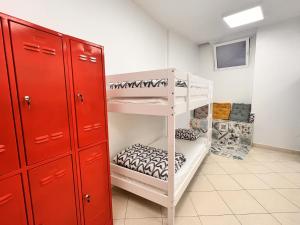 斯普利特Split It Hostel的一间设有白色双层床和红色橱柜的房间