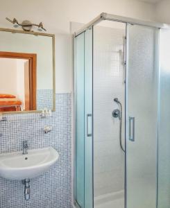 圣梅纳伊欧皮内塔酒店的一间带水槽和玻璃淋浴的浴室