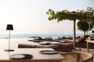 伊亚Canaves Epitome - Small Luxury Hotels of the World的一组躺椅和桌子,享有海景