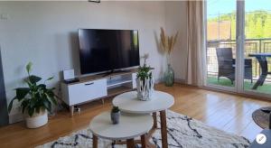 CorcieuxAppartement Cocooning的客厅配有平面电视和桌子。