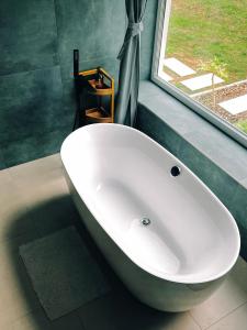 巴拉顿菲兹弗Bambusz apartman的带窗户的浴室内的白色浴缸