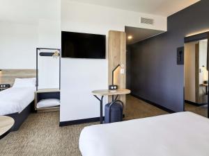 阿让特伊B&B HOTEL Argenteuil的酒店客房设有两张床和一台平面电视。