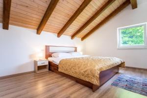 克拉皮纳Apartmani Cerovečki的一间卧室设有一张床和木制天花板