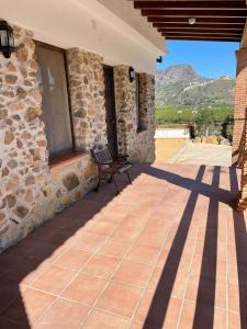 马拉加Habitacion rural en Alora Caminito del Rey的石头房子,在庭院设有长凳