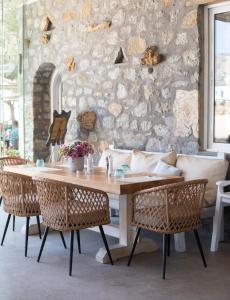 阿格拉瑞Agrari Ninemia Mykonos的石墙客房内的桌椅