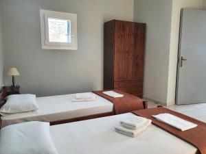 锡基诺斯岛Galini Rooms Sikinos Travel的客房设有两张床和窗户。