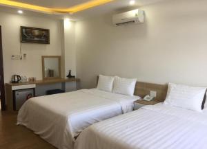 Xóm Mỹ CaLong Hồ Homestay的酒店客房,配有两张带白色床单的床