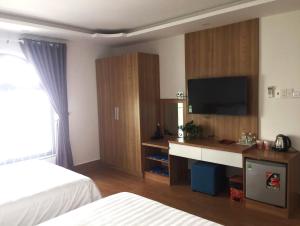 Xóm Mỹ CaLong Hồ Homestay的酒店客房配有一张床和一张书桌及一台电视