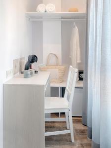 阿尔啼Hostal Perla Blanca Altea的厨房里一张桌子上坐着白色椅子