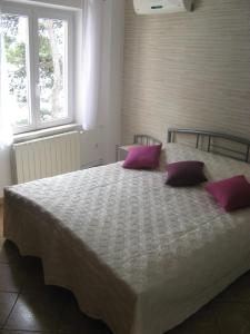 科尔丘拉尼娜公寓和套房酒店的一间卧室配有一张带紫色枕头的大床