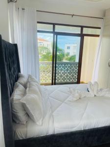 KikambalaLux Suites Sultan Palace Apartments的一间卧室设有一张床,享有海景