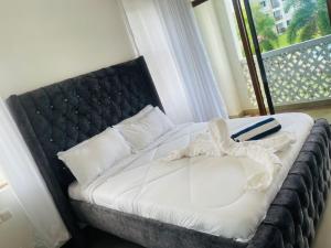 KikambalaLux Suites Sultan Palace Apartments的一间卧室配有一张带黑色床头板的床和窗户