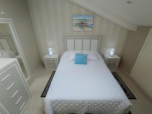 坎巴多斯Fogar San Sadurniño的卧室配有白色床和蓝色枕头