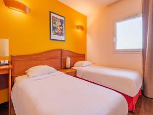 奥尔泽姆B&B HOTEL Strasbourg Aéroport的两张床位于带黄色墙壁的酒店客房