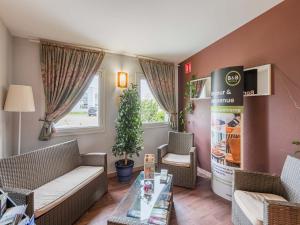 奥尔泽姆B&B HOTEL Strasbourg Aéroport的客厅配有沙发、椅子和桌子