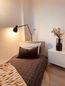 埃姆登Ferienwohnung Altstadtblick的一间卧室配有一张带台灯和枕头的床