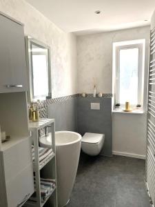 艾森纳赫Ferienwohnung Appartamento Da Vinci的带浴缸和卫生间的浴室以及2扇窗户。