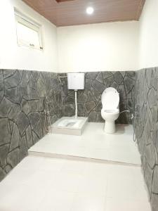 PonedasChogho-Sar Huts的一间带卫生间和石墙的浴室