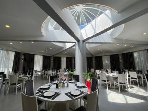 格勒姆Atrium Deluxe Resort的一间带桌椅的用餐室和大窗户