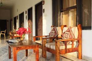 珀勒德布尔Royal Farm Bharatpur的客厅配有两把椅子和一张桌子