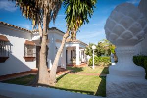 科尼尔-德拉弗龙特拉图里斯提克斯卡波罗施公寓酒店的院子里有棕榈树的白色房子