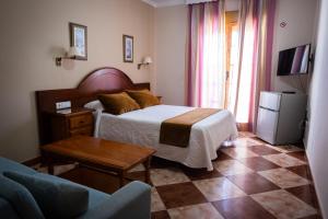 科尼尔-德拉弗龙特拉凯博罗氏旅馆的一间卧室配有一张床、一张桌子和一张沙发